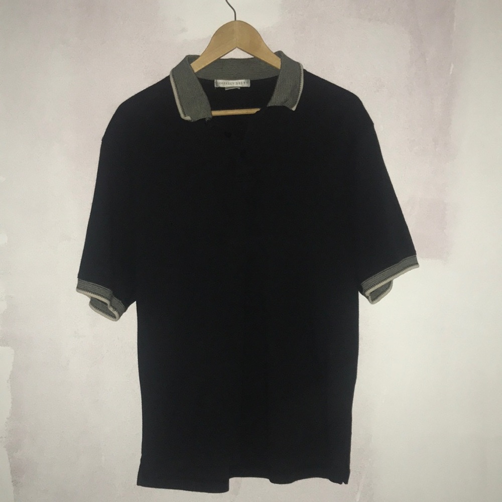 Black cotton polo with neck and sleeve trim.